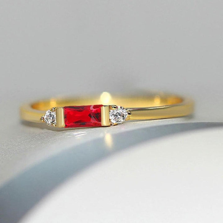 Goldener Ring mit zentralem rotem Stein