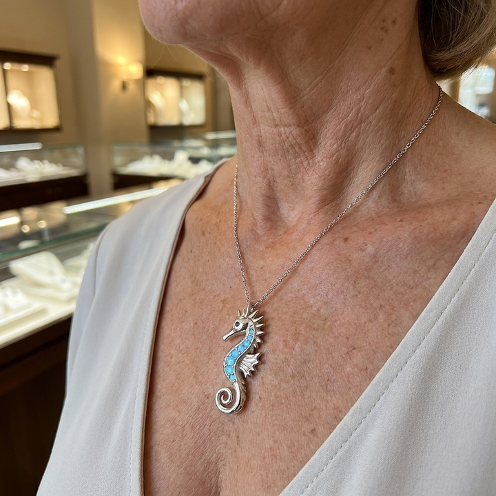 Halskette in Weissgold mit Seepferdchen und Opal am Hals getragen