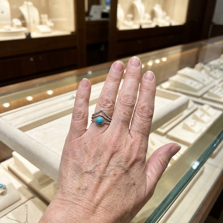 Goldring mit Türkisperlen an der Hand getragen